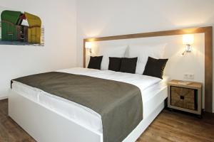 ein großes weißes Bett in einem Zimmer mit einem Tisch in der Unterkunft Wohnung Ostbake in Borkum