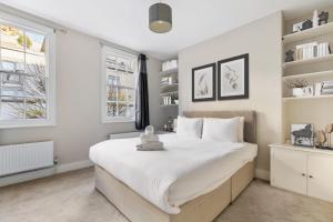 a bedroom with a large white bed and shelves at Heavenly Stays - Victoria in London