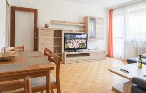 ein Wohnzimmer mit einem Tisch und einem TV in der Unterkunft Apartment Seeblick in Zell am See