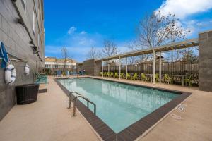 a swimming pool at a hotel with chairs and tables at Home2 Suites By Hilton Baytown in Baytown