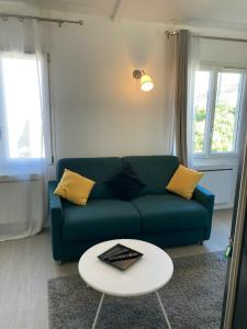 a living room with a blue couch and a table at Studio Chez Eugène in Montreuil