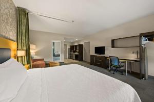 Cette chambre comprend un grand lit et un bureau. dans l'établissement Home2 Suites By Hilton Baytown, à Baytown