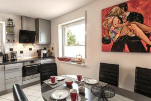 una cocina con una mesa y una pintura en la pared en Haus Stranddüne en Borkum