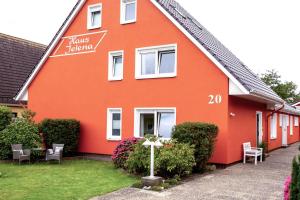 ein rotes Haus mit einem Kreuz davor in der Unterkunft Haus Jelena Appartement 5 in Borkum
