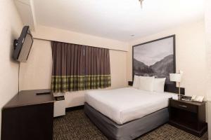 a hotel room with a bed and a television at Super 8 by Wyndham Prince George in Prince George +33 photos