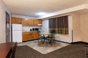 a kitchen with a table and chairs in a room at Super 8 by Wyndham Prince George in Prince George