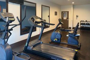 a gym with three cardio machines in a room at Comfort Suites Peoria I-74 in Peoria