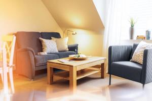 sala de estar con 2 sillas y mesa de centro en Haus Jelena Appartement 2 en Borkum
