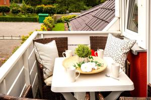 una mesa en un balcón con un plato de comida en Haus Jelena Appartement 2 en Borkum