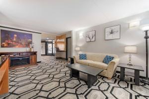 a living room with a couch and a tv at Quality Inn & Suites Mayo Clinic Area in Rochester