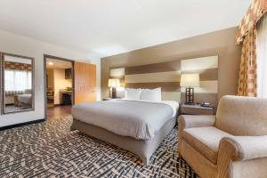 une chambre d'hôtel avec un lit et une chaise dans l'établissement Quality Inn & Suites Mayo Clinic Area, à Rochester