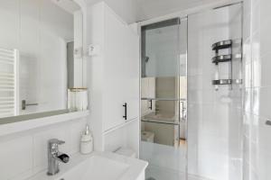a white bathroom with a sink and a shower at 821 Suite Licorne - Superb apartment in Les Lilas