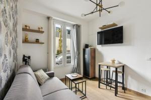 a living room with a couch and a tv and a table at 821 Suite Licorne - Superb apartment in Les Lilas