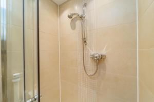 a bathroom with a shower with a glass door at Spacious 3 Bed Townhouse with Parking in Edinburgh