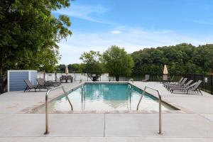 a swimming pool with chairs and a table and a fence at Cozy Lake Cottage W/ Kayaks, SUPs, Pool & Firepit in Winchester