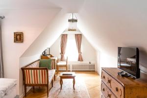 un soggiorno mansardato con divano e TV di Schlossberghotel a Graz