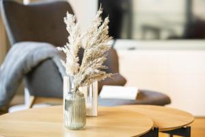 eine Vase mit getrockneten Pflanzen auf einem Tisch. in der Unterkunft Sparkassengebäude Wohnung 2 in Borkum