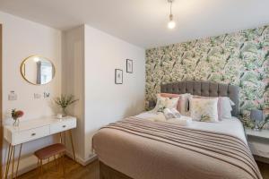 a bedroom with a large bed with a floral wallpaper at Tranquil Urban Haven in London