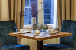 uma mesa de madeira com duas cadeiras e uma mesa com chávenas em Commandeur-Huus Wohnung 2 em Borkum