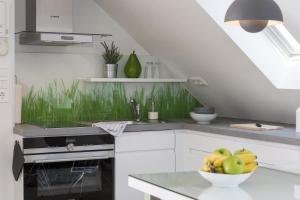 Haus Nordstern Wohnung 5 في بوركوم: مطبخ أبيض مع وعاء من الفواكه على منضدة