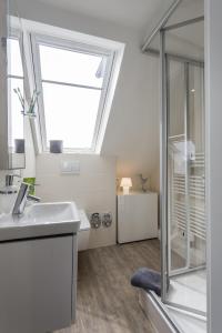 y baño con lavabo y ducha acristalada. en Haus Nordstern Wohnung 5 en Borkum