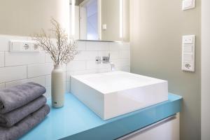 a bathroom with a white sink and a vase at Sparkassengebäude Wohnung 5 in Borkum