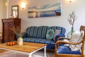 ein Wohnzimmer mit einem blauen Sofa und einem Tisch in der Unterkunft Commandeur-Huus Wohnung 1 in Borkum