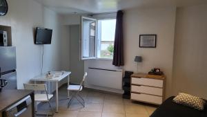 een kleine kamer met een tafel en een raam bij studio Les merles à Saint-Égrève in Saint-Égrève +4 foto's