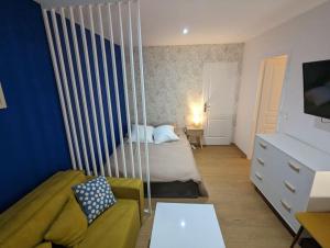 - une chambre avec un lit pliant et un canapé dans l'établissement Le Majorelle-centre ville-accès 24h- parking free, à Montluçon