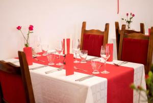 a table with red and white table cloth and wine glasses at István Király Szálló in Pécsvárad