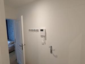 Cette chambre est dotée d'un mur blanc avec une porte. dans l'établissement Le Majorelle-centre ville-accès 24h- parking free, à Montluçon