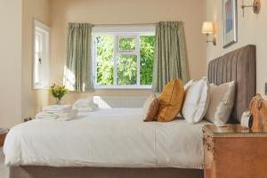 a bedroom with a bed with pillows and a window at Lordington Park in Chichester
