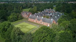 una vista aerea di una grande casa con campo da tennis di DoubleTree by Hilton St. Anne's Manor a Bracknell