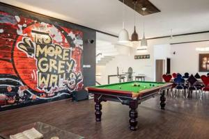 a room with a pool table in front of a mural at Long Stay Villa in Swiss Town! in Devanahalli-Bangalore