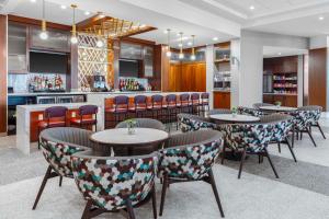 a restaurant with tables and chairs and a bar at Hyatt Place St Augustine Vilano Beach in Saint Augustine