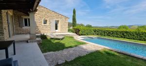 a swimming pool in a yard next to a house at mas des oliviers in Gordes