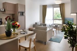 a living room with a kitchen and a living room with a table at DOMITYS - Le Solstice in Versailles
