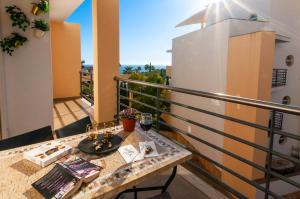 un balcón con una mesa con copas de vino. en Encosta da Orada by OCvillas, en Albufeira