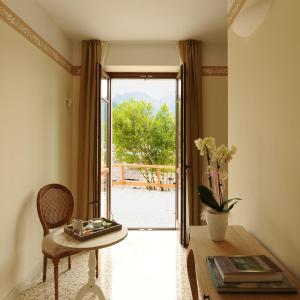 a living room with a table and a door with a view at La Villa degli Orti in Borgo