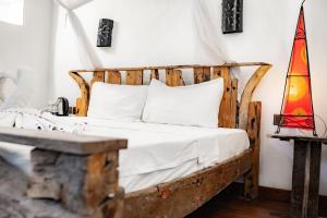 um quarto com uma cama e uma cabeceira em madeira em Zanzi House em Zanzibar