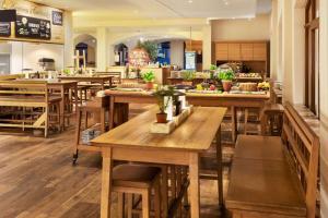 a restaurant with many wooden tables and chairs at Amedia Plaza Dresden, Trademark Collection by Wyndham in Dresden