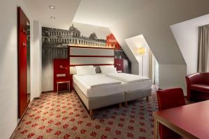 a hotel room with a bed and a table and chairs at Amedia Plaza Dresden in Dresden
