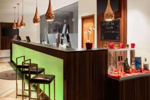 a bar in a restaurant with chairs and a counter at Amedia Plaza Dresden, Trademark Collection by Wyndham in Dresden