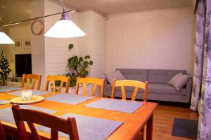 ein Wohnzimmer mit einem Tisch, Stühlen und einem Sofa in der Unterkunft Spacious house in Rovaniemi / Lapland (11 beds) in Rovaniemi