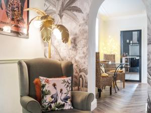 a living room with a chair with a pillow at Clematis House in Saint Columb Major