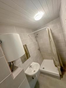 Baño blanco con lavabo y aseo en Votre Havre de Paix à Perpignan en Perpiñán