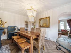 a dining room with a wooden table and chairs at Clematis House in Saint Columb Major