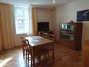 a dining room with a table and chairs and a television at Apartament nad strumykiem Lądek-Zdrój in Lądek-Zdrój