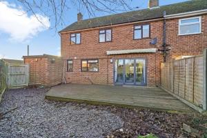 a brick house with a wooden deck in front of it at Ideal 4 bed House in Rugby - Football Table in Clifton upon Dunsmore