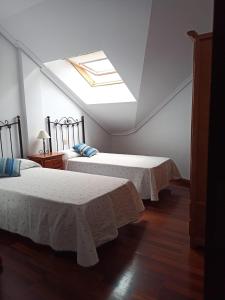 a bedroom with two beds and a skylight at CASA MANUELA in Suances